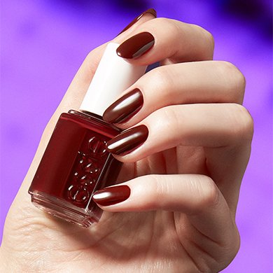 Light skin model wearing the essie nail polish shade full blast against a dark purple background