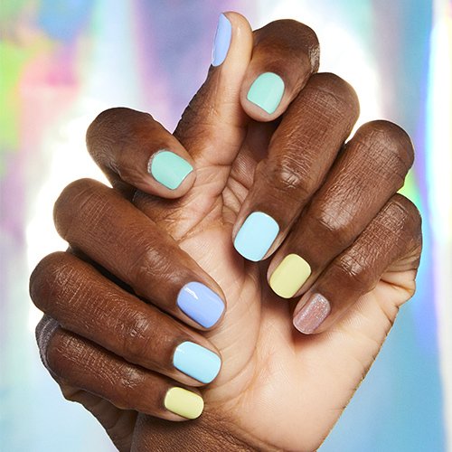 Deep skin tone model hands wearing different neon pastel nail color on each finger.