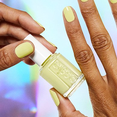 Model wearing chartreuse yellow nail polish holding you’re scent-sational essie nail polish bottle.