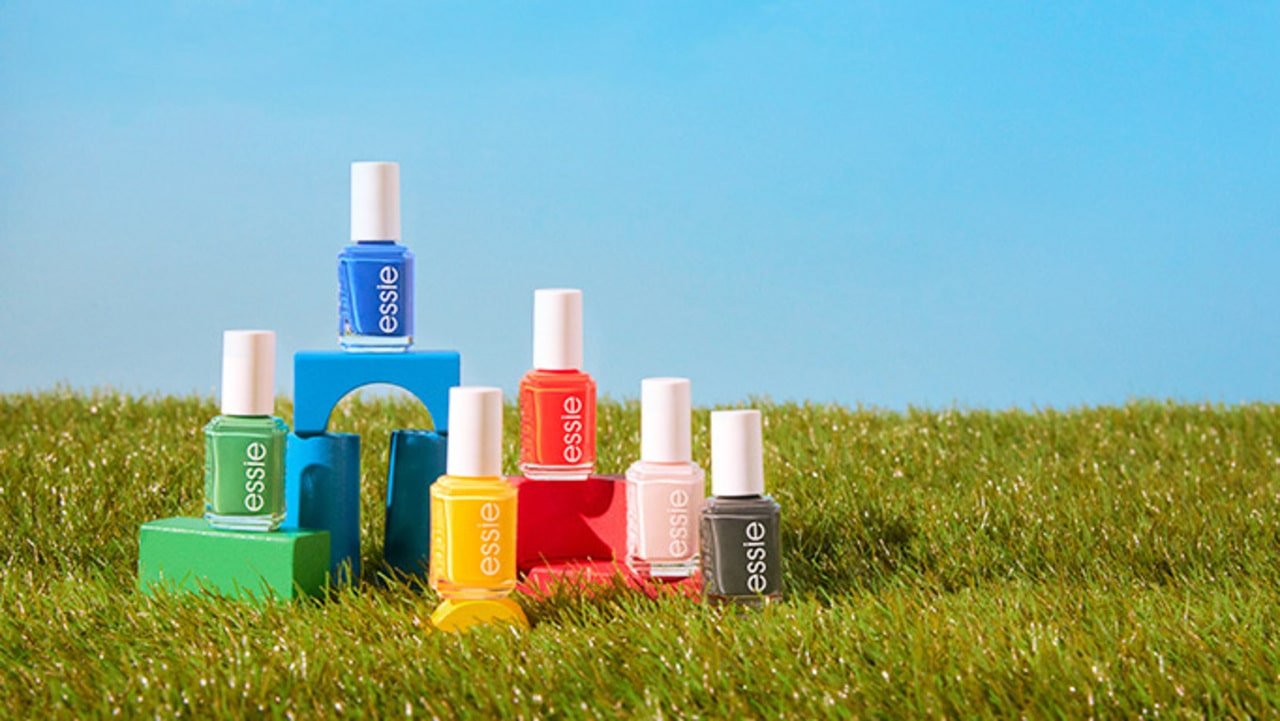 Six nail polish bottles containing the 6 shades from the push play collection against a blue sky background and displayed on colorful blocks