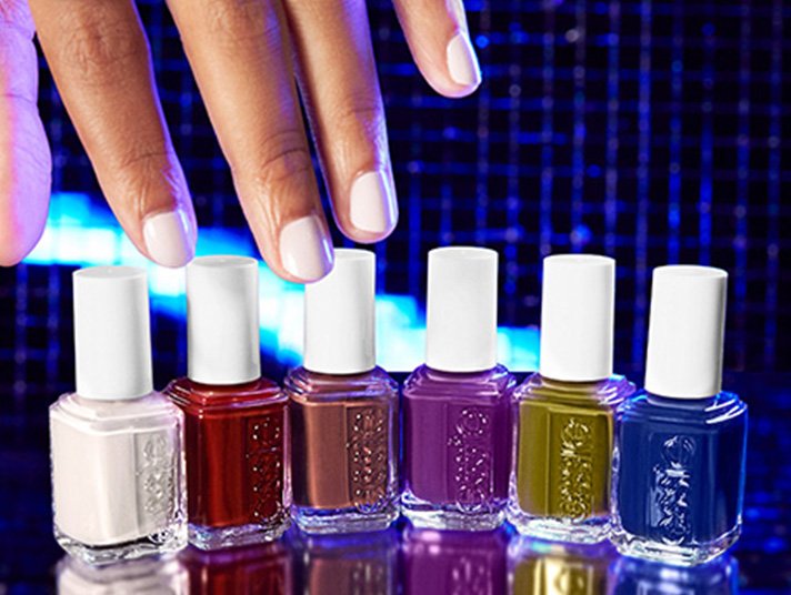 Light skin hand reaching down for the 6 bottles of essie fall 2023 shades