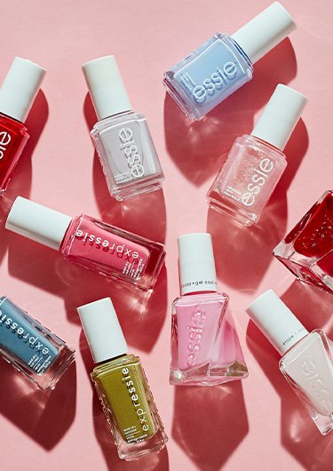 Overview of ten different bottles of essie nail polish arranged randomly on a pale pink surface